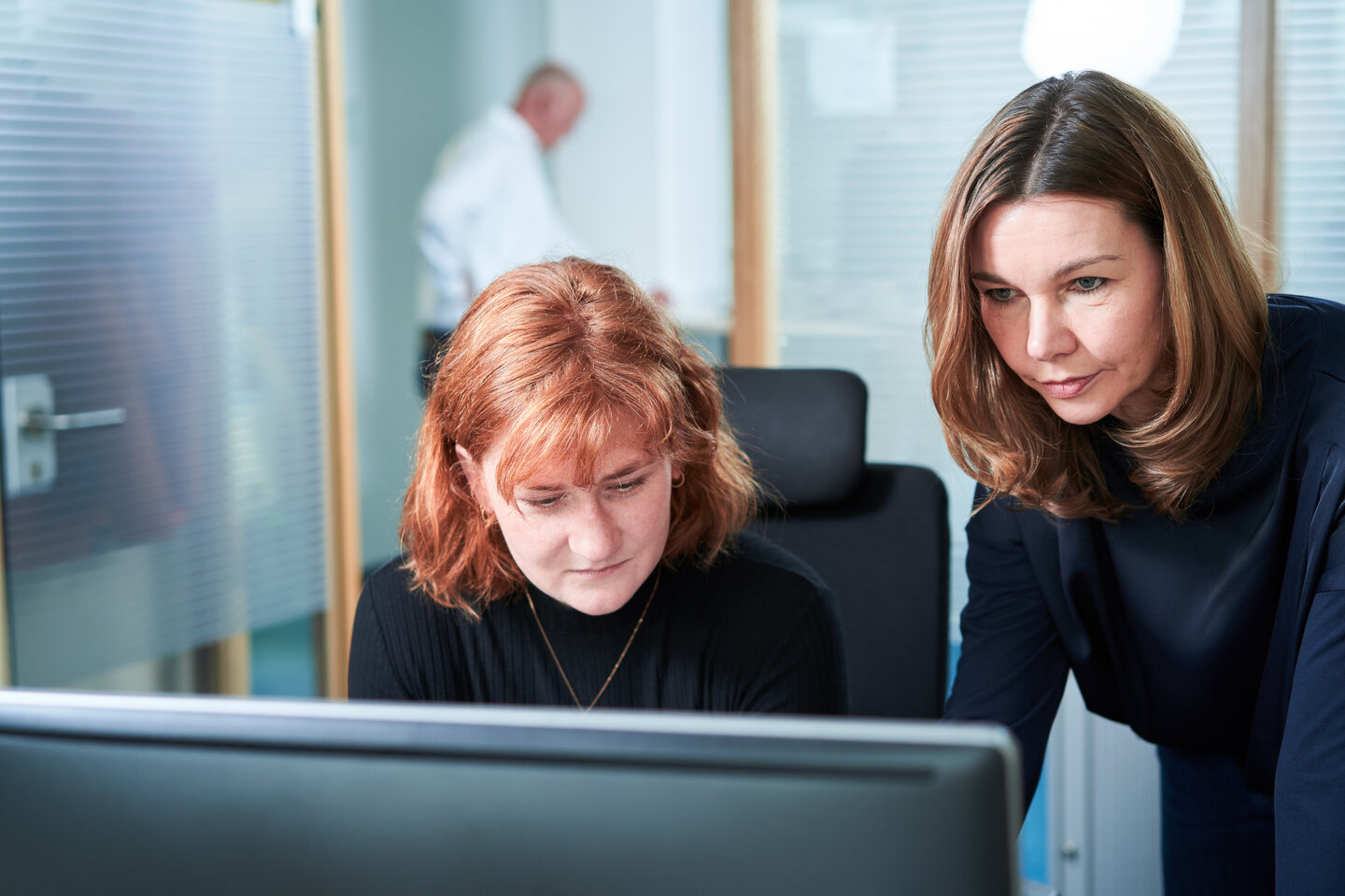 Kolleginnen schauen auf wichtige Dokumente am Computer