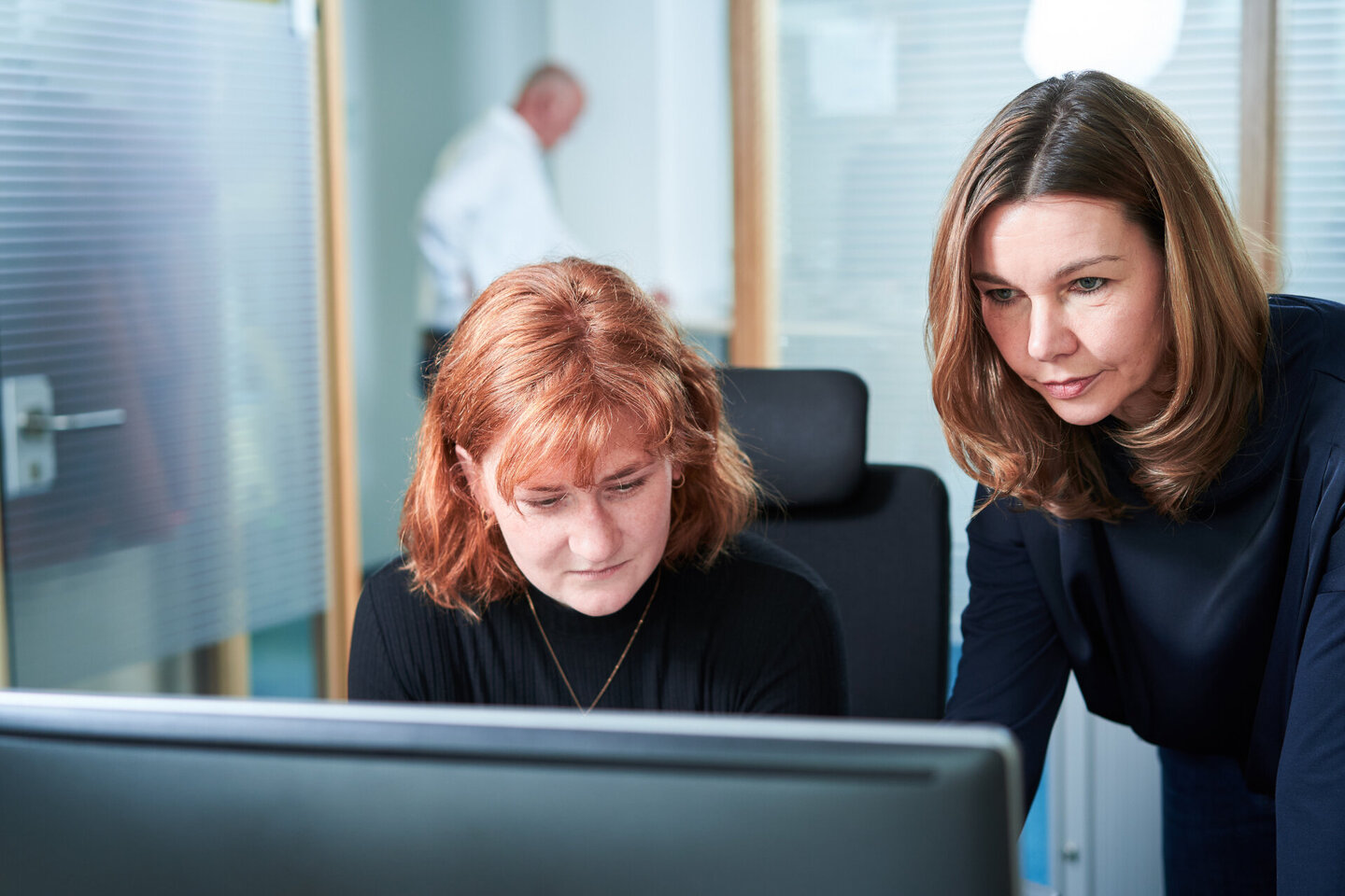 Kolleginnen schauen auf wichtige Dokumente am Computer